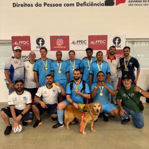 Equipe e comissão técnica do Instituto Nova Visão, uniformizados e perfilados em pé e agachados com a medalha de campeão paulista de 2024.